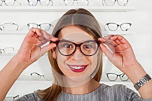 Young woman choosing eyeglass frame
