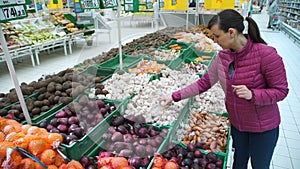 Young woman choosing garlic at the supermarket