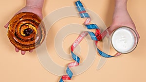 The young woman choosing between glass of yogurt and sweet pastry. Concept healthy eating