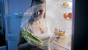 Young woman choosing healthy food instead of sweets. Concept of healthy nutrition and dieting