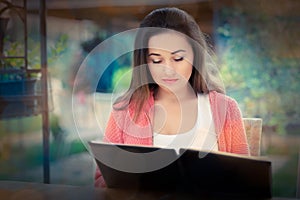 Young Woman Choosing from a Restaurant Menu