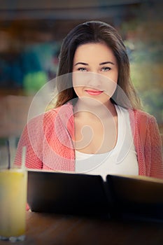 Young Woman Choosing from a Restaurant Menu