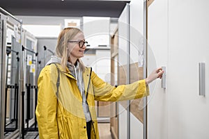 Young woman choosing the right furniture for her apartment in a modern home furnishings store shopping for furniture in