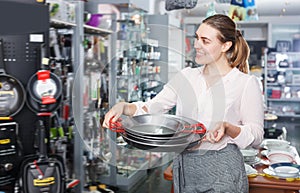 Young woman is choosing set of stewpot