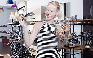 Young woman choosing from two pairs of shoes