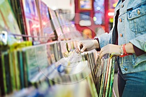 Young Woman Choosing Vintage Vinyl LP In Records Shop