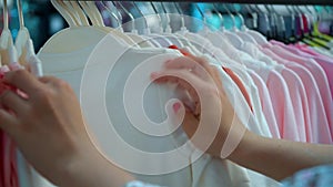 Young woman chose a t-shirt in the store. Shopping girl