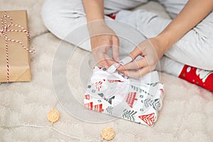 Young woman on Christmas morning opens gifts for the new year