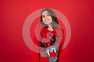 Young woman in a Christmas sweater on a red background photo