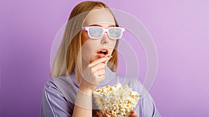 Young woman in cinema glasses watching 3d movie in cinema. Smiling teenager girl movie viewer in glasses eating popcorn