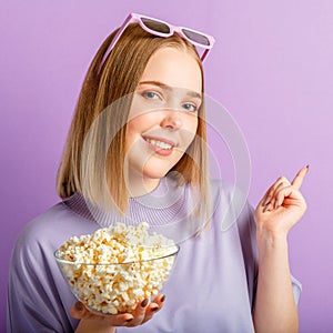 Young woman in cinema glasses watching 3d movie. Smiling teenager girl movie viewer in glasses with popcorn show side by