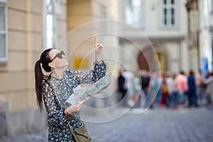 Young woman with a city map in city. Travel tourist girl with map in Vienna outdoors during holidays in Europe.