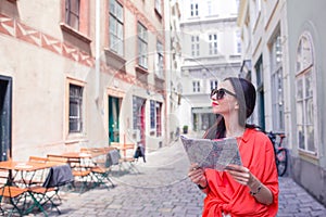 Young woman with a city map in city. Travel tourist girl with map in Vienna outdoors during holidays in Europe.