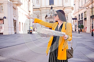 Young woman with a city map in city. Travel tourist girl with map in Vienna outdoors during holidays in Europe.