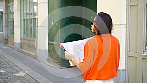 Young woman with a city map in city. Travel tourist girl with map in Vienna outdoors during holidays in Europe.