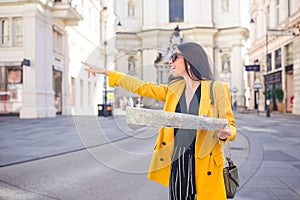 Young woman with city map in city. Travel tourist girl with map in Vienna outdoors during holidays in Europe.