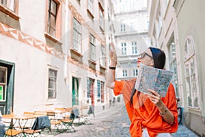 Young woman with a city map in city. Travel tourist girl with map in Vienna outdoors during holidays in Europe.