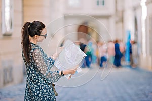 Young woman with a city map in city. Travel tourist girl with map in Vienna outdoors during holidays in Europe.