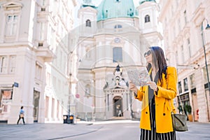 Young woman with a city map in city. Travel tourist girl with map in Vienna outdoors during holidays in Europe.