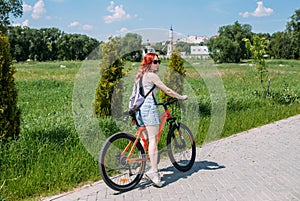 Young woman in the city rides bike and leads an active lifestyle doing sports