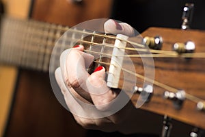 Young woman clamped with fingers guitar strings photo