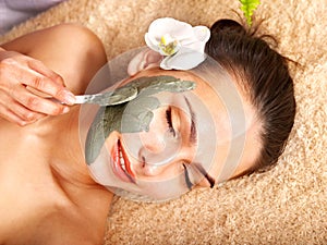 Young woman with clay facial mask.