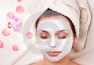 Young woman with clay facial mask.