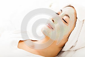 Young woman with clay facial mask