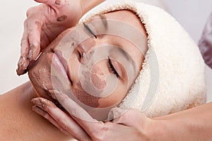 Young woman with clay facial mask.