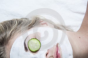 Young woman with clay facial mask in spa salon