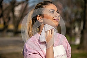 Young woman clean face and neck with wet wipes