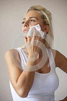 Young woman clean face with wet wipes