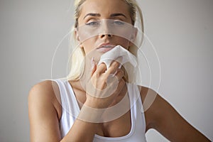 Young woman clean face with wet wipes