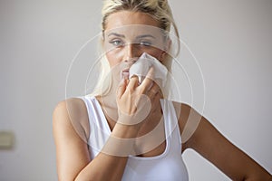 Young woman clean face with wet wipes