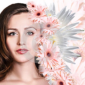 Young woman with clean skin over flowers.