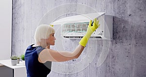 Young Woman Cleaning Air Conditioning System