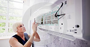 Young Woman Cleaning Air Conditioning System