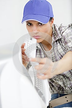 young woman cleaning air conditioning system at home