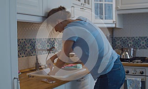 Young woman cleaning a blockage in a kitchen sink