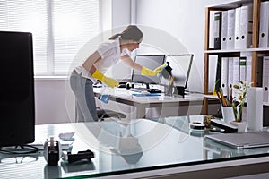 Woman Cleaning Computer In Office photo