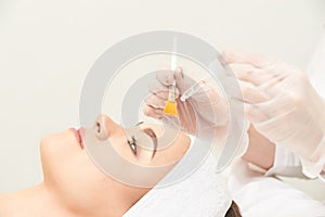 Young woman cleaning face skin in salon. Retinol peel with brush. Acid organic peeling