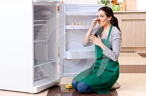 Young woman cleaning fridge in hygiene concept