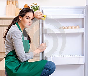 Young woman cleaning fridge in hygiene concept