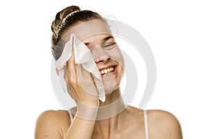 Young woman cleaning her face with wet wipe