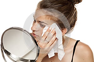 Young woman cleaning her face with wet wipe