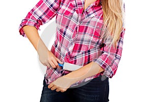 Young woman cleaning her shirt with lint roller