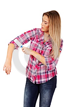 Young woman cleaning her shirt with lint roller