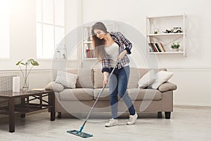 Young woman cleaning house with mop