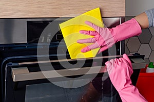 Young woman cleaning oven in the kitchen photo