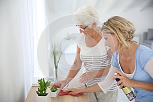 Young woman cleaning senior's home